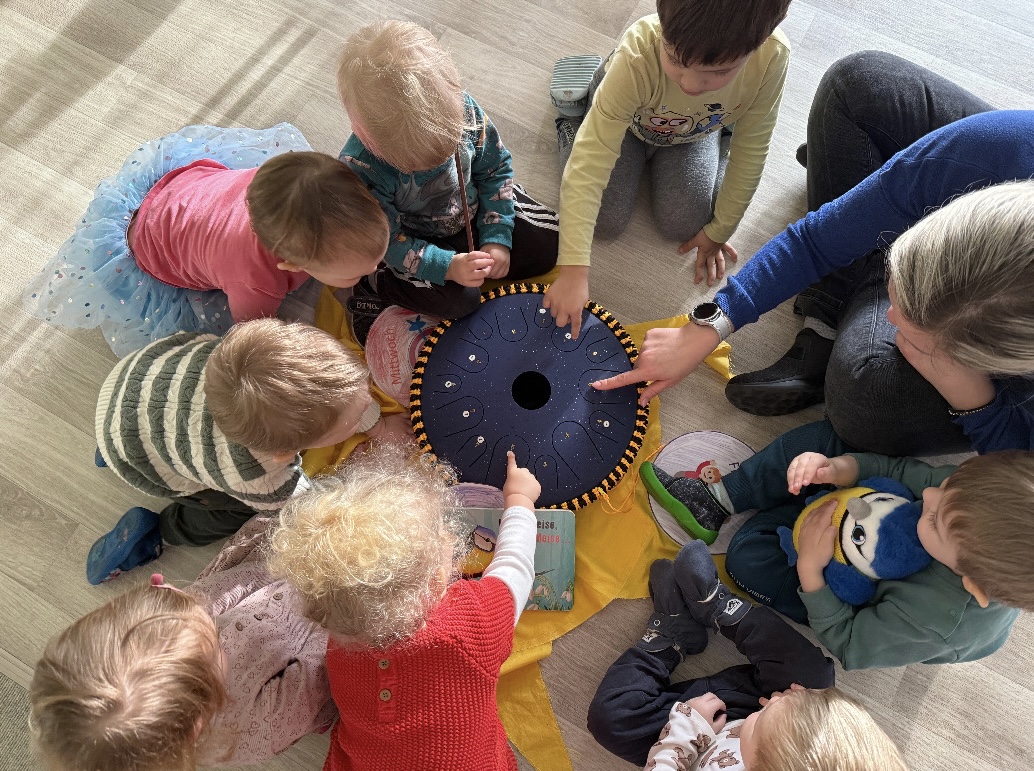 sonodrum bringt faszination kinder sitzen im kreis um Musikinstrument
