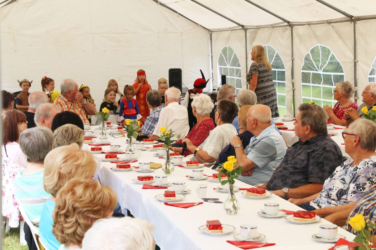 Sommerfest im Betreuten Wohnen Senioren schauen das programm der Kita-Kinder gespannt an